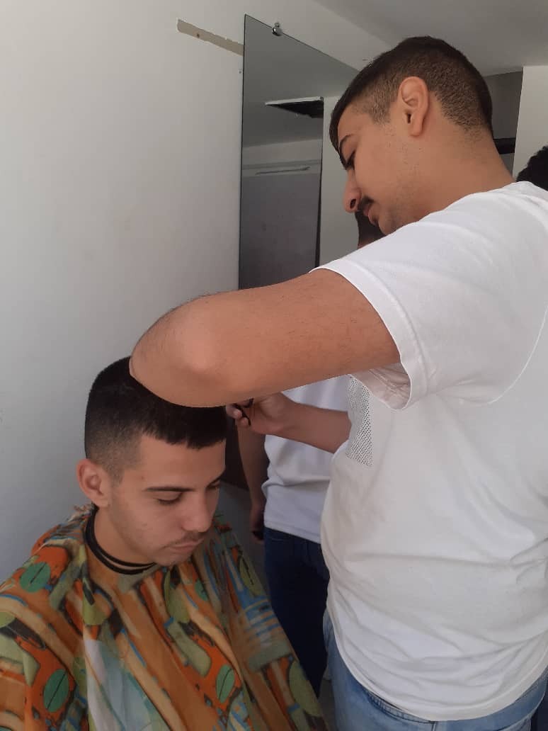 متدرب يطبّق قصة شعر في دورة الحلاقة الرجالية — مركز فور هيلب حمص